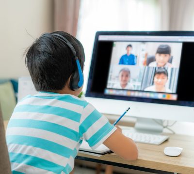 Asian boy student video conference e-learning with teacher and classmates on computer in living room at home. Homeschooling and distance learning ,online ,education and internet.