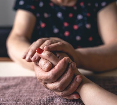 Old and young female hands are holding, elderly care and respect, close-up.